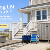 Family-friendly Long Beach Island vacation rental exterior with outdoor shower, beach wagon, chairs, and easy beach-access setup for parents traveling with kids