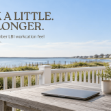 September LBI workcation with closed laptop on a coastal deck overlooking the bay