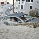 LONG BEACH ISLAND,NJ-NOVEMBER 1: A car is badly damaged by the storm surge and sand caused by Hurricane Sandy in Holgate.Nov 1 2012, Long Beach Island, NJ